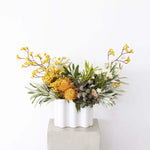 Designing Flowers in A Vase Workshop showcasing a beautiful floral arrangement in a modern white vase.