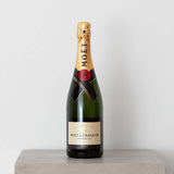 Add-on: Moet Brut Champagne bottle elegantly displayed on a gray surface, showcasing the iconic Moët & Chandon label.