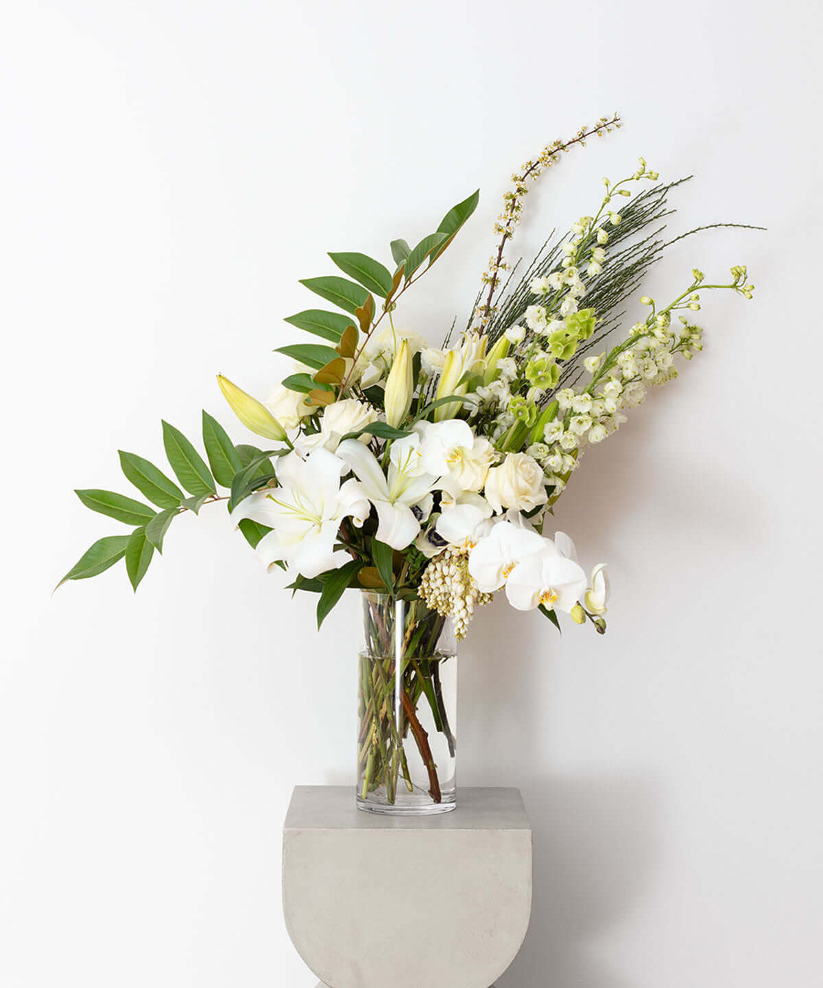 Symphony of White and Green Bouquet arranged in a clear vase with elegant white and green flowers.
