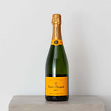 Add-on: Veuve Cliquot Champagne bottle with iconic yellow label on display.